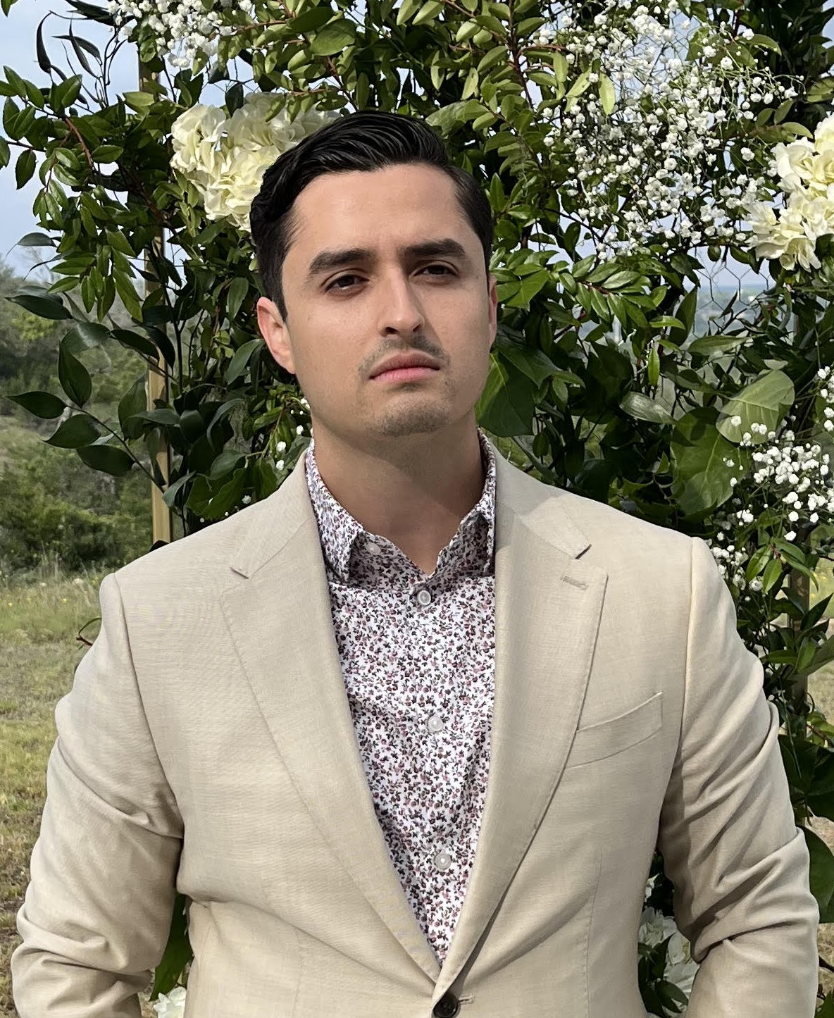 Michael Villarreal staring into the future in a tan suit.